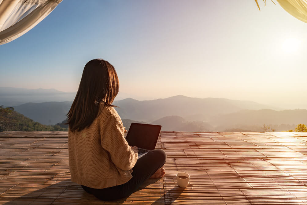 woman working outside using a laptop